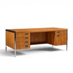 Wooden desk with four left drawers and two right drawers, open central knee space, and metal legs and trim.